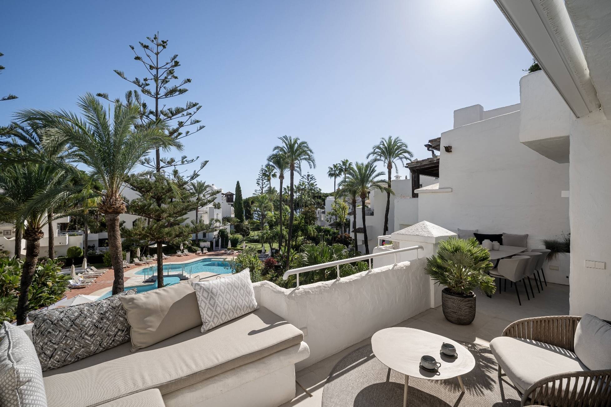 Terrace with built-in seating overlooking the gardens, pools and palm trees