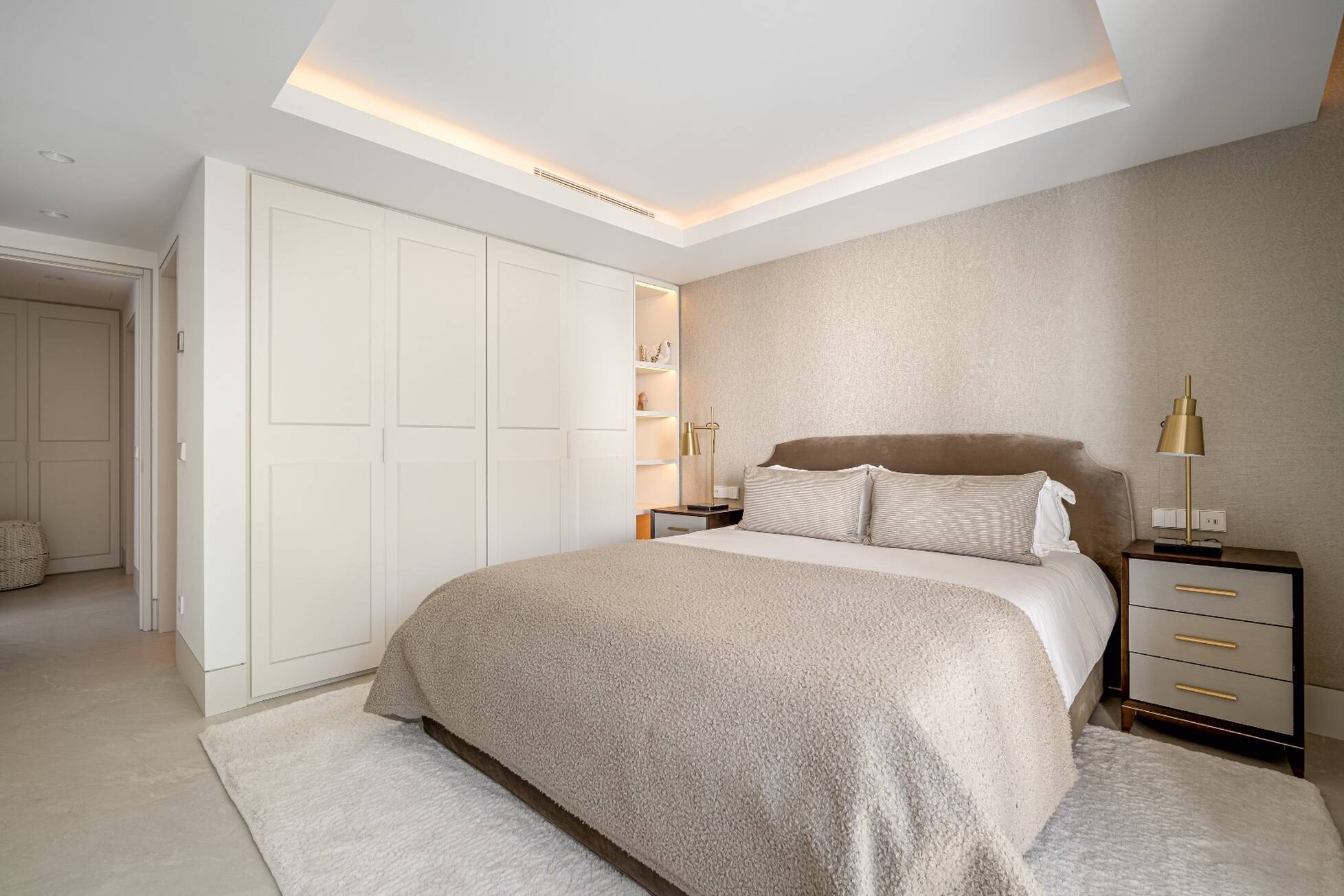 Bedroom with fitted wardrobes, textured wallcovering and soft cove lighting