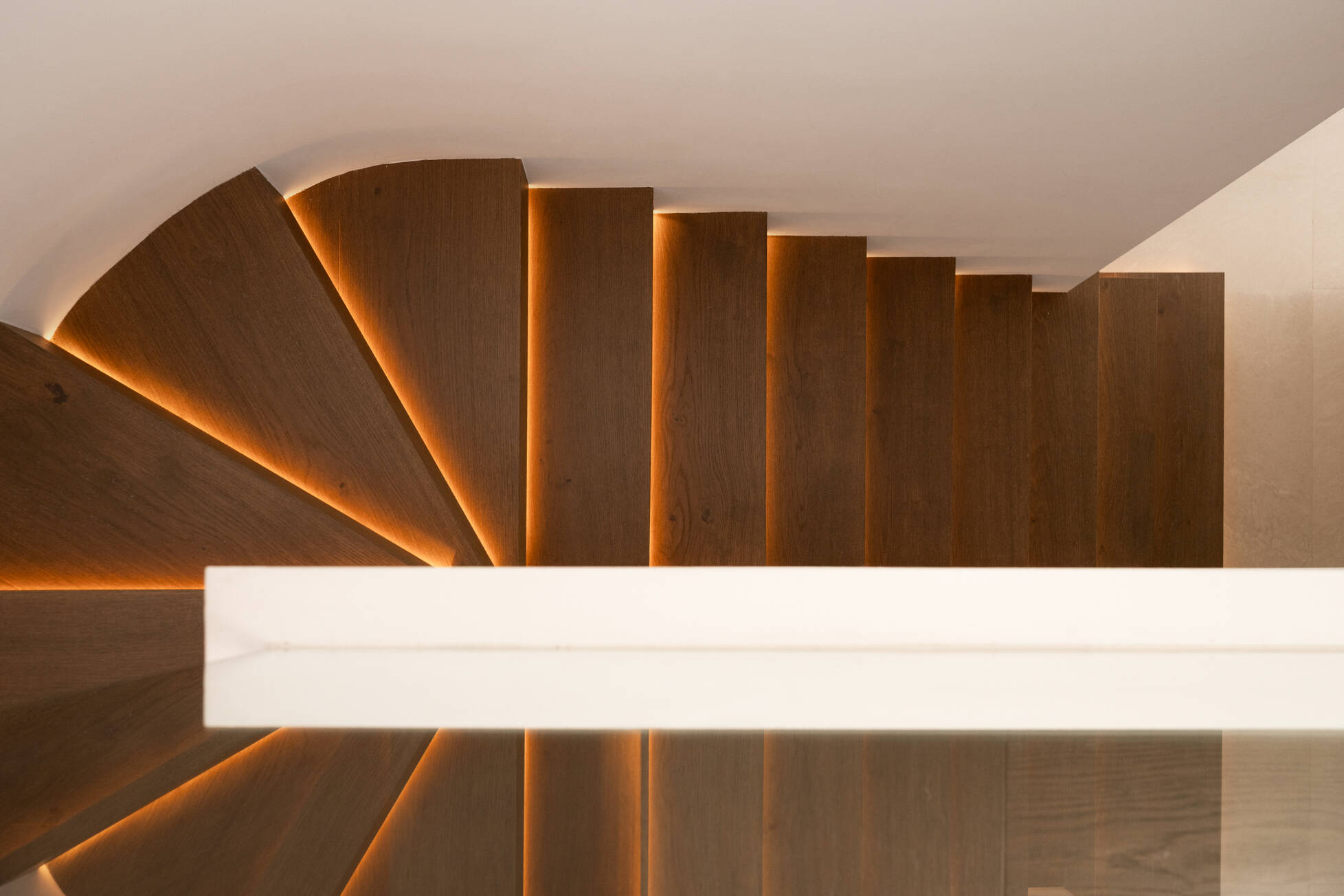 Detail of the sculptural oak staircase with concealed lighting beneath each tread