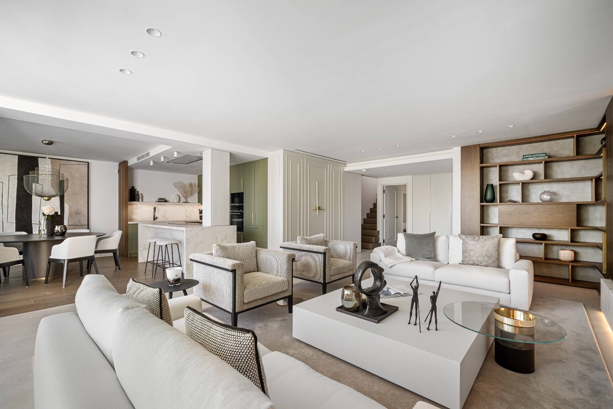 Wide view of the reception rooms with bespoke oak shelving and a marble kitchen island