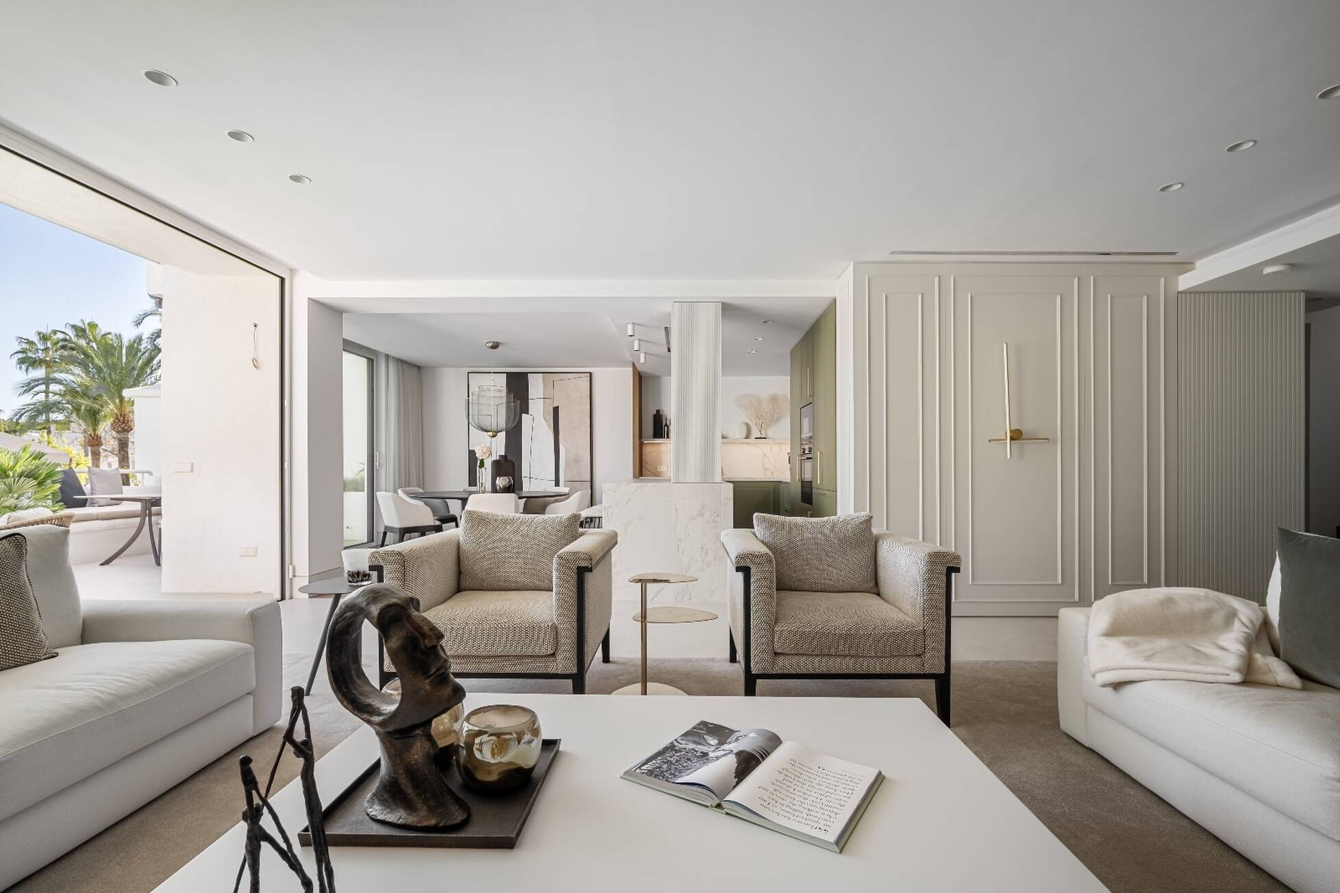 Living and dining areas flowing together beneath a fluted column in the Marbella penthouse